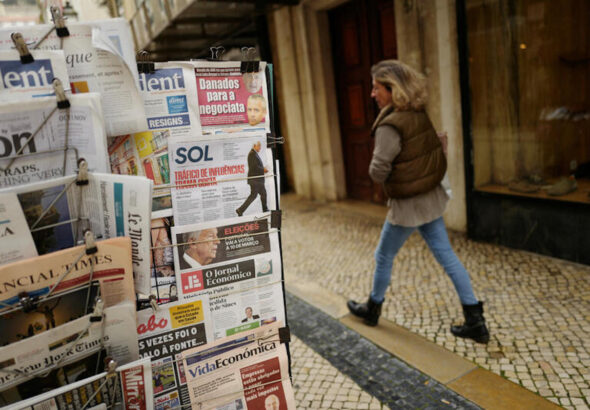 A woman passes by a newspaper stand, a day after Portugal's President Marcelo Rebelo de Sousa announced his decision to dissolve parliament triggering snap general elections on March 10th 2024, in Lisbon